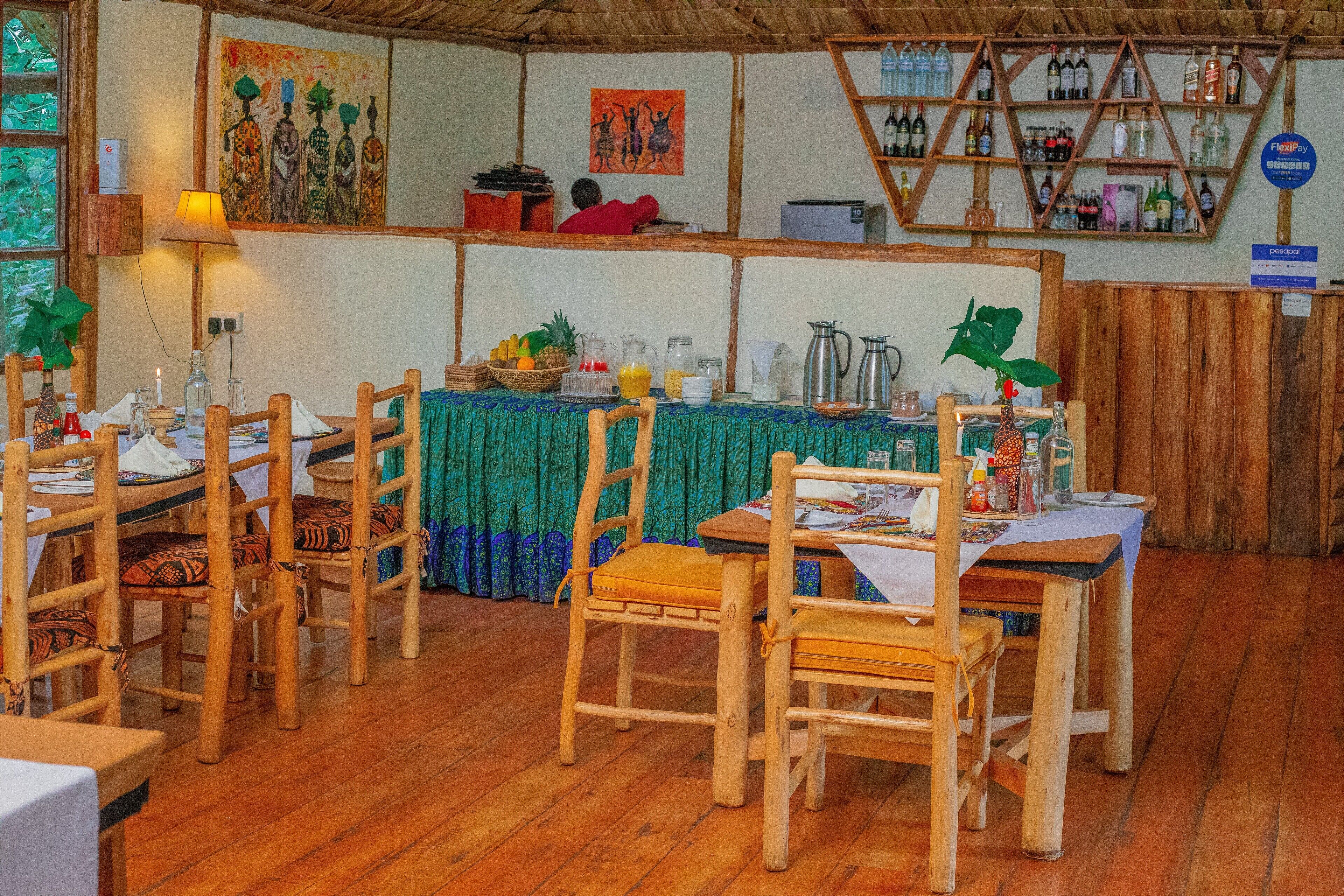 Un ristorante con mobili in legno, una tovaglia verde e una varietà di piatti e bevande sul tavolo.