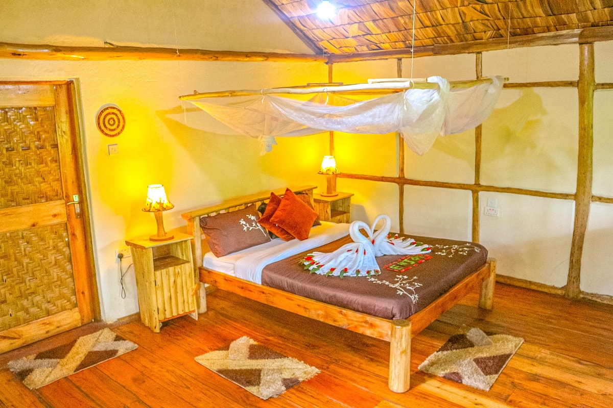 A bed with a canopy, two bedside lamps, and a decorative swan on the bedspread.