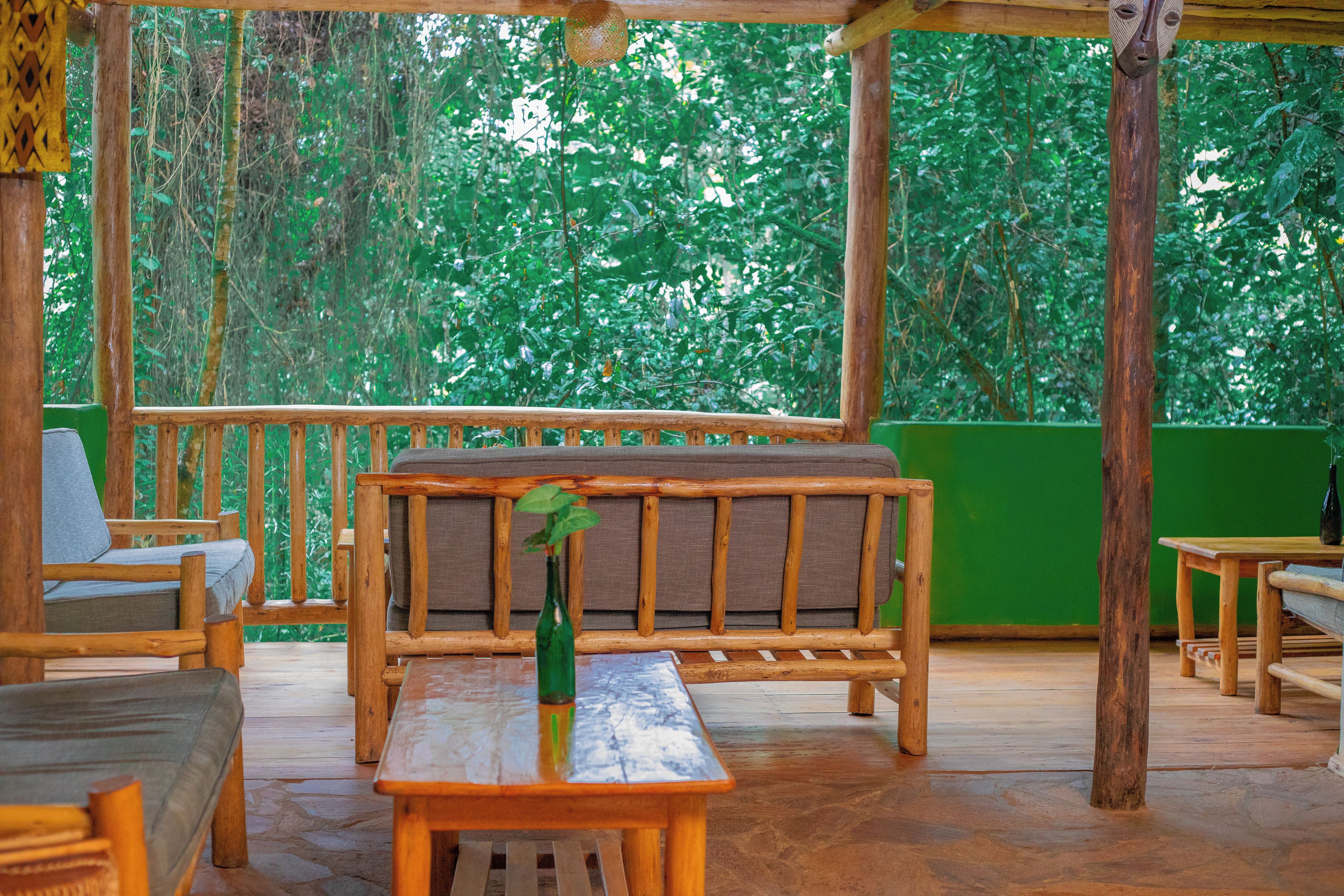 An outdoor wooden deck with a bench, chairs, and a table.