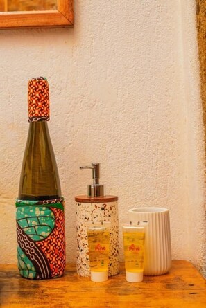 A bottle, a dispenser, and two containers on a wooden surface.