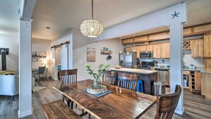 Eine moderne Küche mit Holzausstattung, einer zentralen Kochinsel und einem Essbereich mit Holztisch und Stühlen.