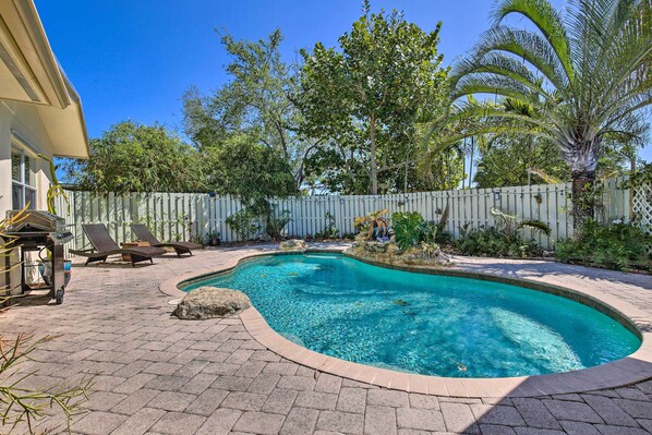 A backyard with a swimming pool, lounge chairs, and a wooden deck. - Vacation Rental w/ Private Pool in Wilton Manors (Wilton Manors)