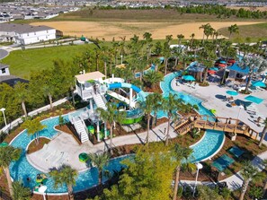 A water park with multiple pools, slides, and a large sandy area.