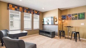 A living room with a flat-screen TV, a fireplace, a coffee table, and a seating area.