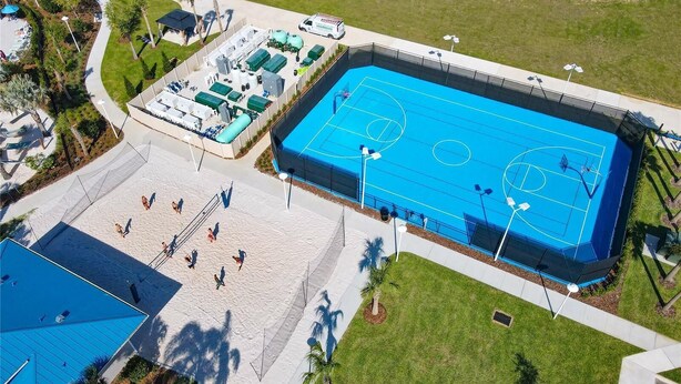 Ovenfra set et sportskompleks med en basketballbane, en tennisbane og en swimmingpool.