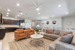 A modern living room with a sofa, armchairs, and a coffee table.