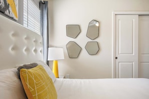 A hotel room with a bed, a nightstand, a lamp, and a door. - Themed family retreat with epic game room (Davenport)