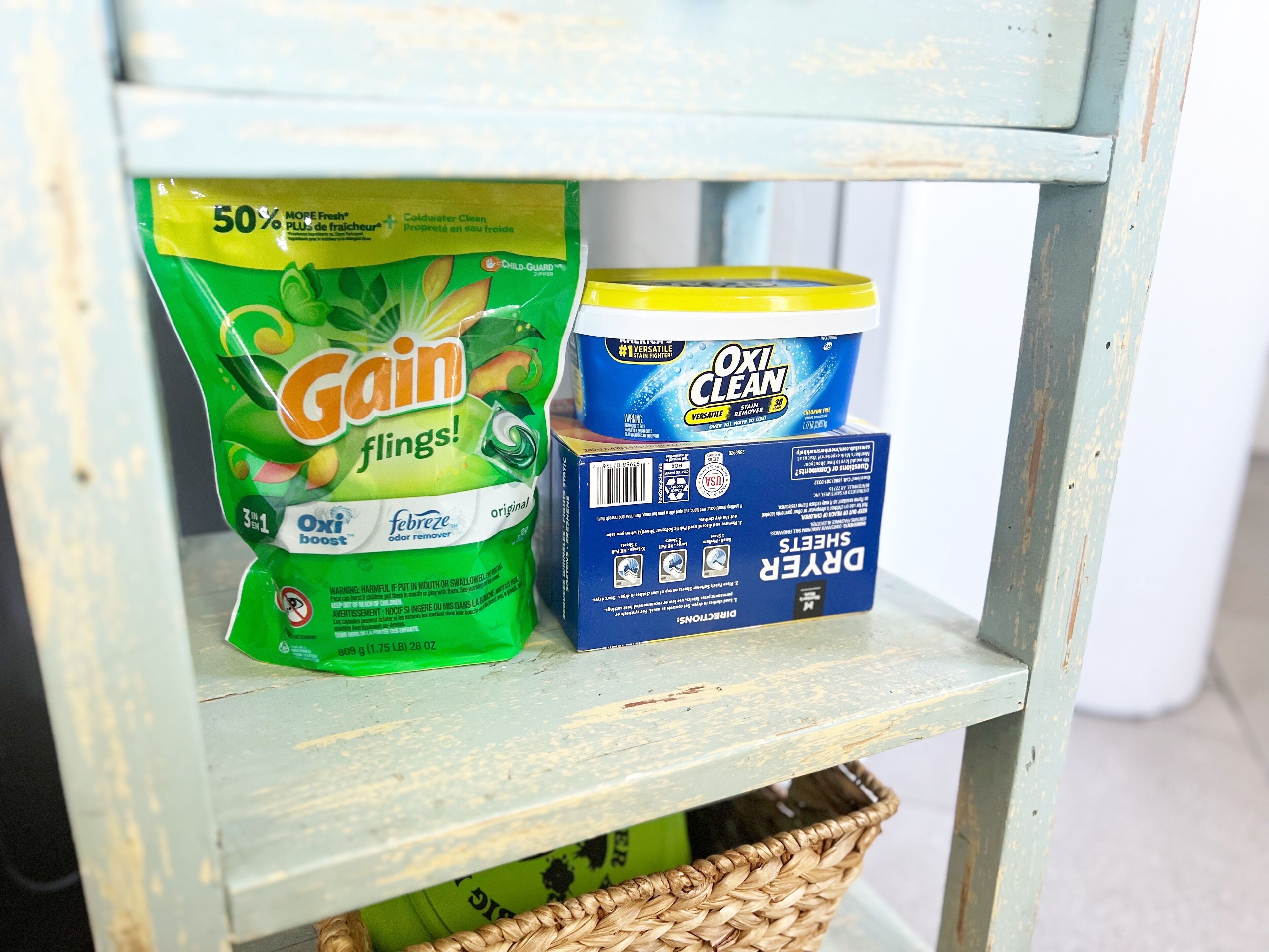 Hyllyllä on pakkaus Gain Flings! -pyykinpesuaineita ja pakkaus Oxi Clean -pyykinvalkaisuainetta.