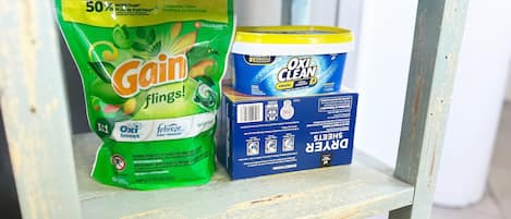 Hyllyllä on pakkaus Gain Flings! -pyykinpesuaineita ja pakkaus Oxi Clean -pyykinvalkaisuainetta.