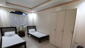 A bedroom with two beds, a wardrobe, and a heater. - OYO 799 Ddd Habitat Iloilo (Iloilo)