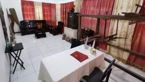 A room with a dining table, chairs, a sofa set, and curtains. - OYO 799 Ddd Habitat Iloilo (Iloilo)