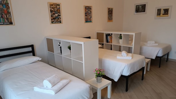 Une chambre d’hôtel avec un lit, une petite table agrémentée d’une plante et un coin salon avec une table et des chaises.