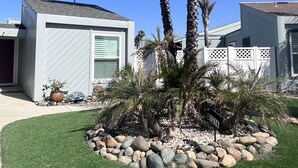 A residential area with modern houses, a well-maintained lawn, and a palm tree. - Paradise Home in Discovery Bay minutes to fast water (Discovery Bay)