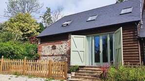 Una casa rústica con fachada de piedra, revestimiento de madera y una puerta verde.