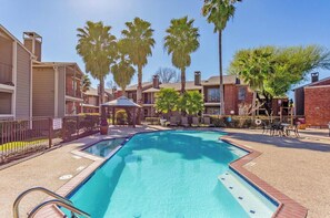 Guests can enjoy a refreshing swim in the pool surrounded by lounge chairs and a gazebo.