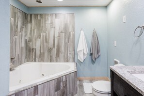 Tina de hidromasaje, toallas, papel de baño