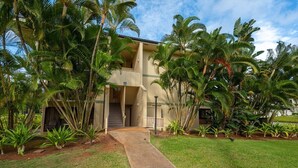 A two-story building with a concrete pathway leading to the entrance.
