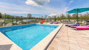 A swimming pool with a slide, lounge chairs, and umbrellas. - Lovely home in Ornice (Ornice)
