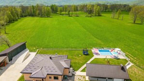 A residential area with a large green field, a swimming pool, and houses with sloped roofs. - Lovely home in Ornice (Ornice)