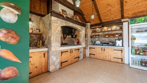 A rustic kitchen with stone walls, wooden cabinets, and a built-in oven. - Lovely home in Ornice (Ornice)