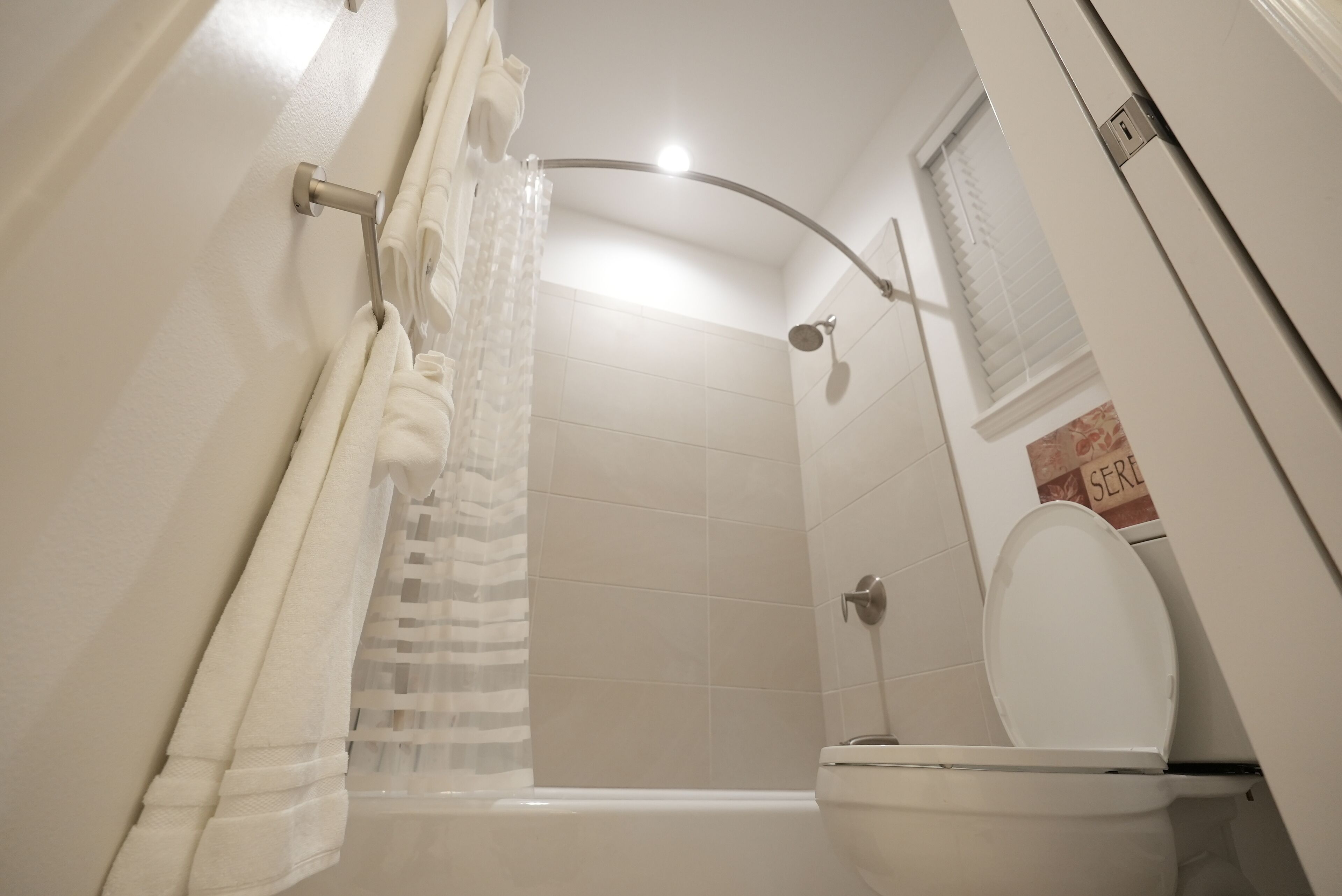 Une salle de bain équipée d’une douche, de toilettes et d’un porte-serviettes.