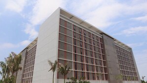 Un edificio moderno con una fachada de ventanas en forma de cuadrícula y techo plano.