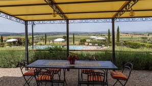 A covered outdoor seating area with a table and chairs, overlooking a pool and garden. - Private Villa with A/C, private pool, WIFI, patio, pets allowed, panoramic view, close to Cortona (Creti)