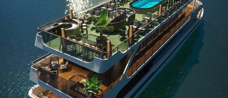 A cruise ship with a rooftop pool, outdoor seating, and a glass-enclosed lounge area.
