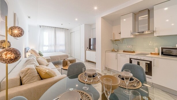 A modern apartment with a dining area, kitchen, and living room. - Housing El Rastro by Sharing Co (Madrid)