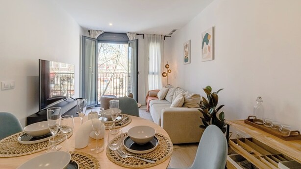 Ein modernes Wohnzimmer mit Essbereich, einer Couch und einem Fernseher.