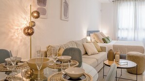 Een moderne hotelkamer met een eethoek, een bank, een bed en een groot raam.