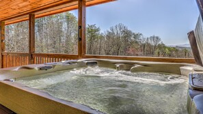 A hot tub with a wooden deck and a view of a forested area. - Tranquility Ranch - Hot Tub | Pool Table | Fire Pit in Private Yard (Mineral Bluff)