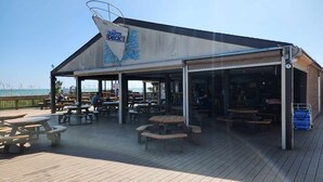 A beachside restaurant with outdoor seating and a view of the ocean. - ^^Amazing Ocean View, Super Clean w/ Towels/Linen,1G WIFI @ Myrtle Beach Resort  (Myrtle Beach)