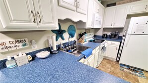 A kitchen with white cabinets, a blue countertop, and a sign that says "NO CRABBY attitudes". - ^^Amazing Ocean View, Super Clean w/ Towels/Linen,1G WIFI @ Myrtle Beach Resort  (Myrtle Beach)