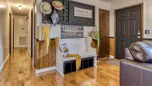 A cozy entryway with a bench, a 'Happy Home' sign, and a 'farmhouse-ish' sign. - Farmhouse Cottage - Close to Tanger Outlets and Pigeon Forge! (Sevierville)