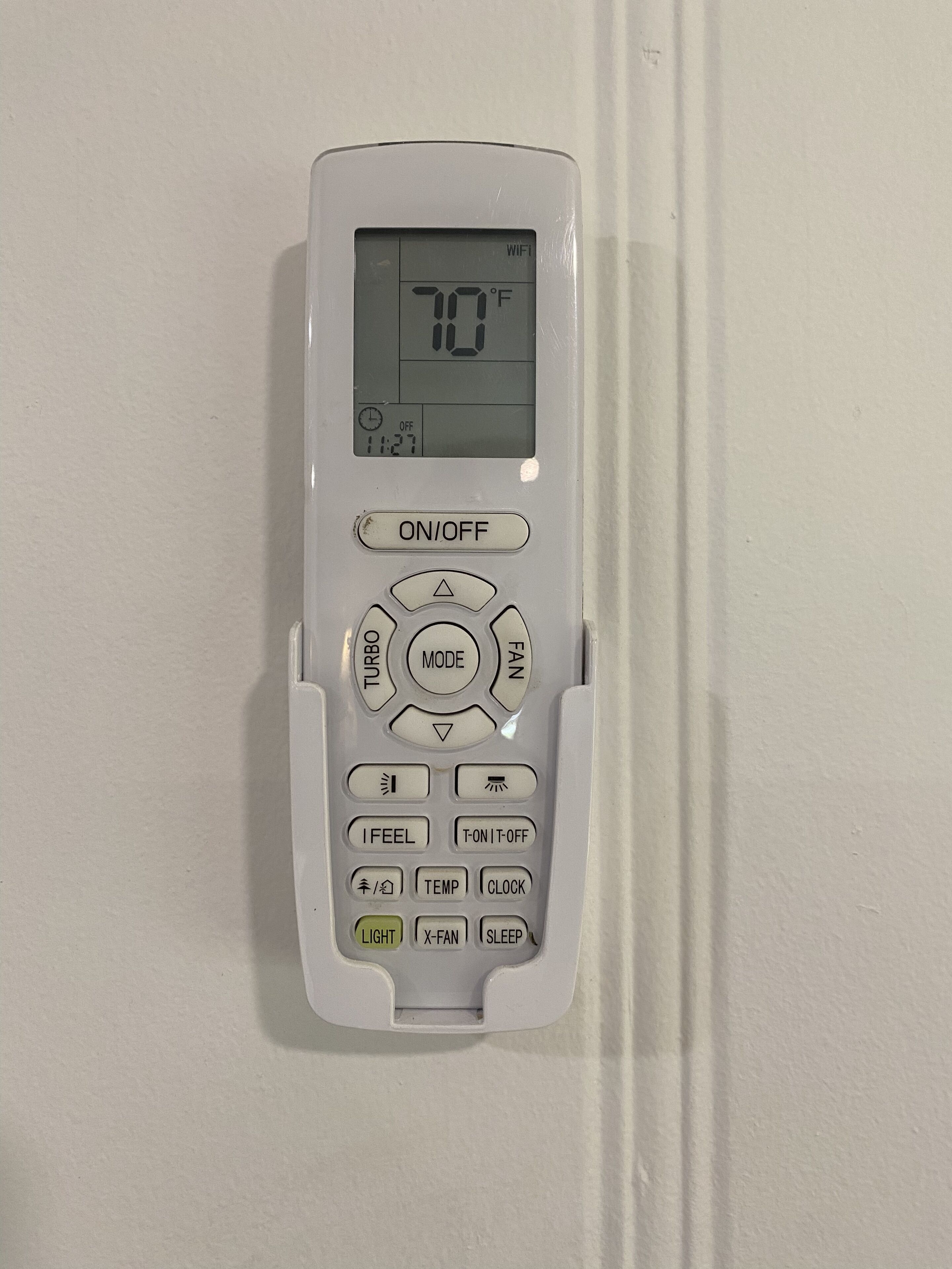 Un termostato con pantalla digital, interruptor de encendido/apagado, selector de modo y varios botones de control.