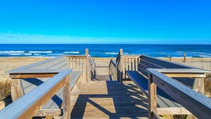 A wooden boardwalk leading to the beach with a clear view of the ocean.