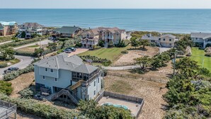 A coastal residential area with houses, a swimming pool, and a view of the ocean.