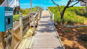 A wooden boardwalk leading to a beach with a sign instructing to clean up after pets. - The Salty Lab - Beautiful Ocean & Sound views in this 5 BR "Dog Friendly" home! (Duck)