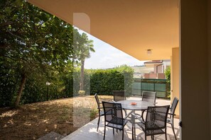 An outdoor patio with a table and chairs, surrounded by greenery and a view of the neighborhood. - Villa Mila with beautiful sea view (Pineto)