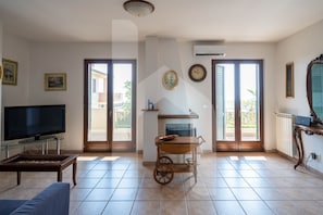 A living room with a TV, sofa, and a cart. - Completely independent and with its own private garden, Villa Mila is strategically located, ideal for those wishing to enjoy a beach vacation in the peace and quiet of a residential area well connected to the city center. (Pineto)