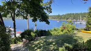 Une zone herbeuse offrant une vue sur un lac et des bateaux.