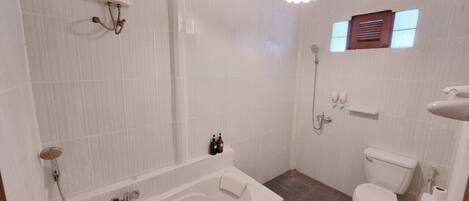 Un baño con bañera, inodoro y ducha.