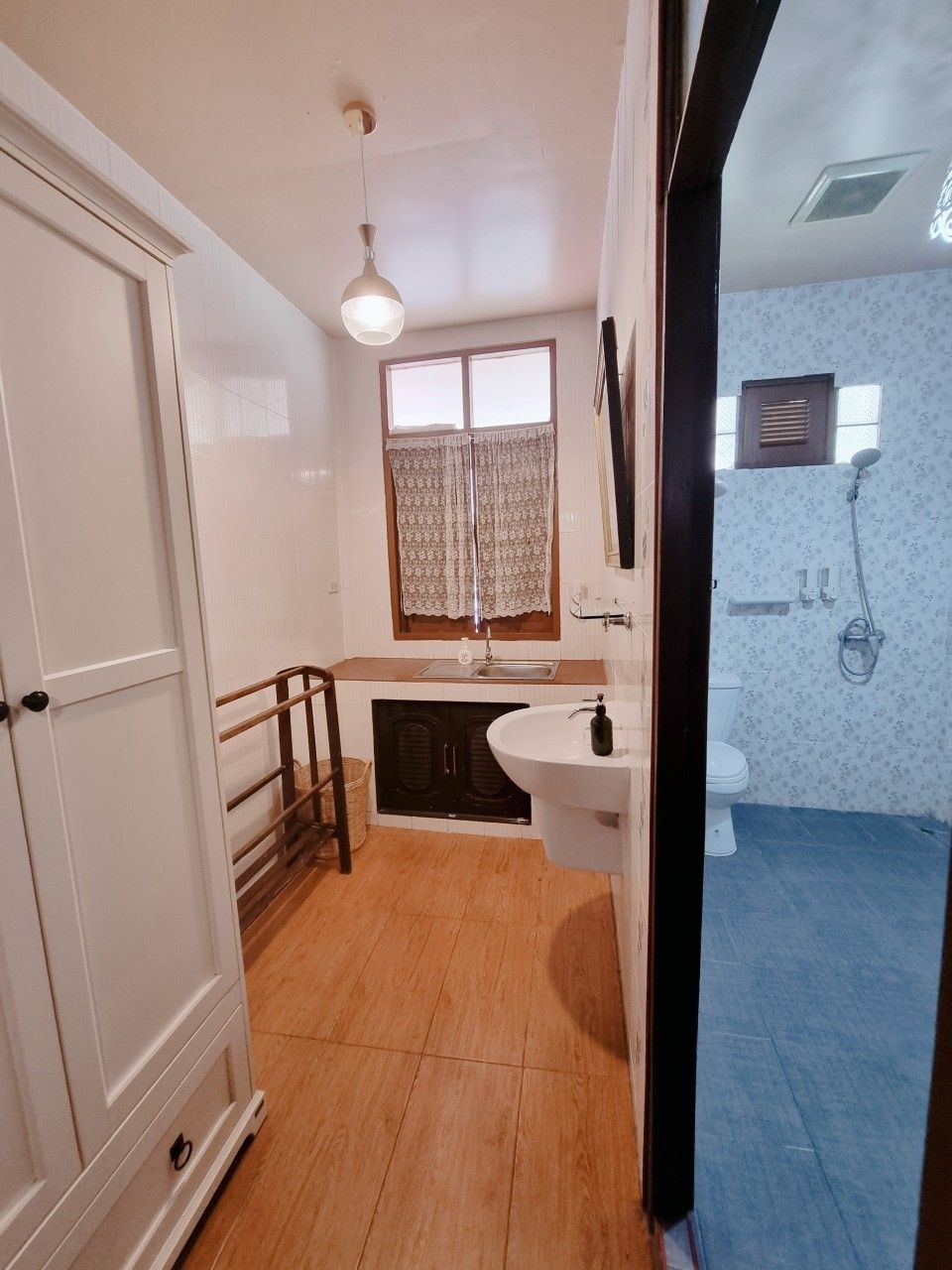 A bathroom with a sink, toilet, and shower area.