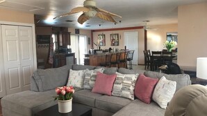 A living room with a sectional sofa, a coffee table, and a ceiling fan. - Gorgeous Pool house 5 min from the beach, shopping and restaurants I (Venice)