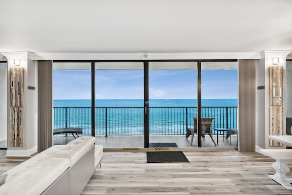 Ein geräumiger Balkon mit Meerblick, ausgestattet mit einer gepolsterten Sitzecke und einem Tisch.