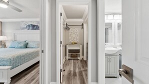 A hallway with a bed, a fireplace, and a bathroom.