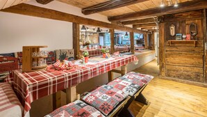 Un interior rústico con vigas de madera, manteles a cuadros y bancos.