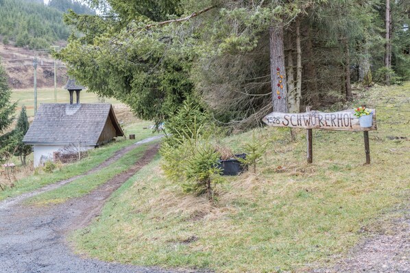 Un entorno rural con un letrero de madera que indica el lugar llamado 'Schwörerhof'.