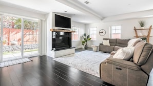 A living room with a fireplace, a sectional sofa, and a large window.